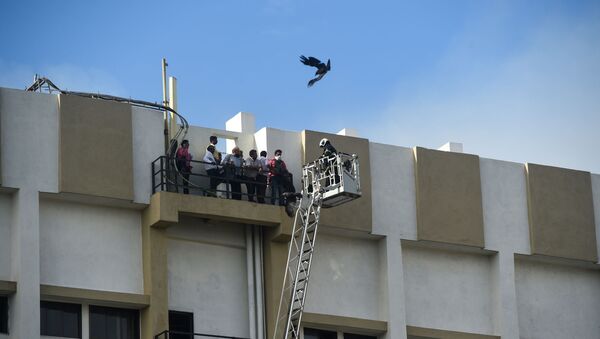 People are rescued by firefighters using a crane as they are trapped in a building caught on fire in Mumbai on July 22, 2019 - Sputnik International