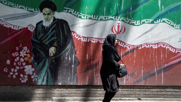 An Iranian woman walks in front of a mural of Iran's late leader Ayatollah Ruhollah Khomeini in Tehran, Iran July 7, 2019 - Sputnik International