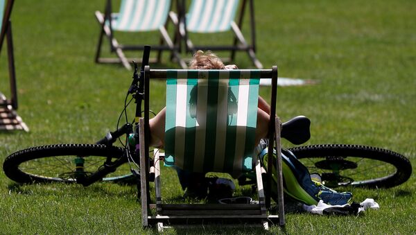 A cyclist rests in the sun in St James' Park in London, Britain, June 29, 2019.  - Sputnik International