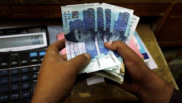 A trader counts Pakistani rupee notes at a currency exchange booth in Peshawar, Pakistan December 3, 2018 - Sputnik International