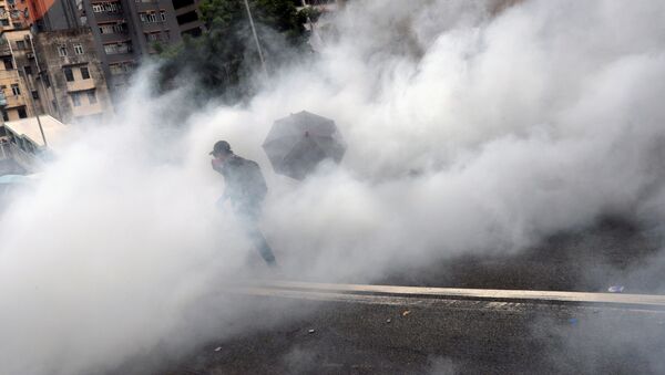 A demonstrator is seen amidst smoke from tear gas during a protest against the Yuen Long attacks in Yuen Long - Sputnik International