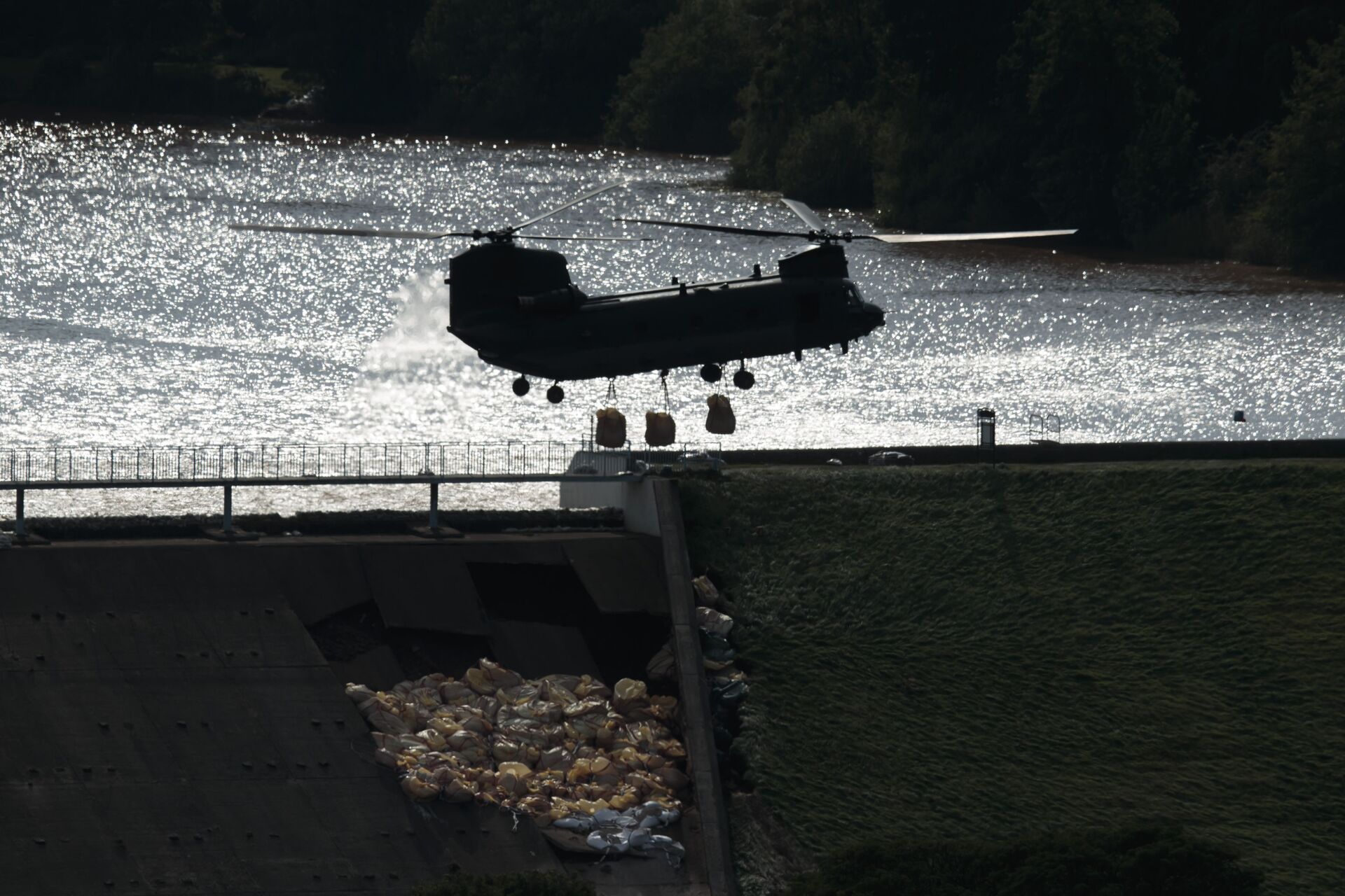 An RAF Chinook helicopter drops aggregate to help shore up a reservoir at risk of collapse, threatening to engulf the town of Whaley Bridge in the Peak District, England, Friday - Sputnik International, 1920, 06.08.2022