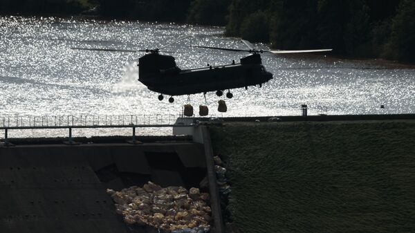 An RAF Chinook helicopter drops aggregate to help shore up a reservoir at risk of collapse, threatening to engulf the town of Whaley Bridge in the Peak District, England, 2 August 2019 - Sputnik International