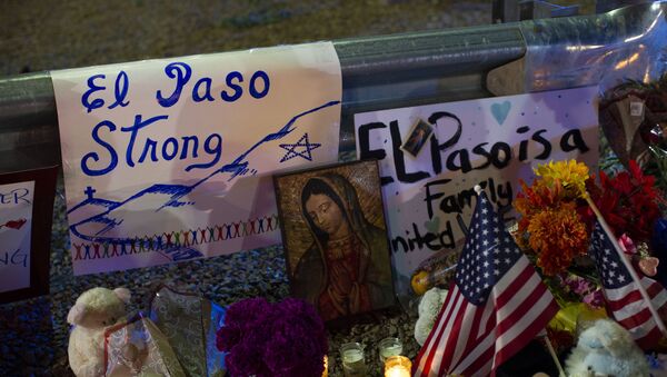 A Virgin Mary painting, flags and flowers adorn a makeshift memorial for the victims of Saturday's mass shooting at a shopping complex in El Paso, Texas, Sunday, 4 August 2019 - Sputnik International