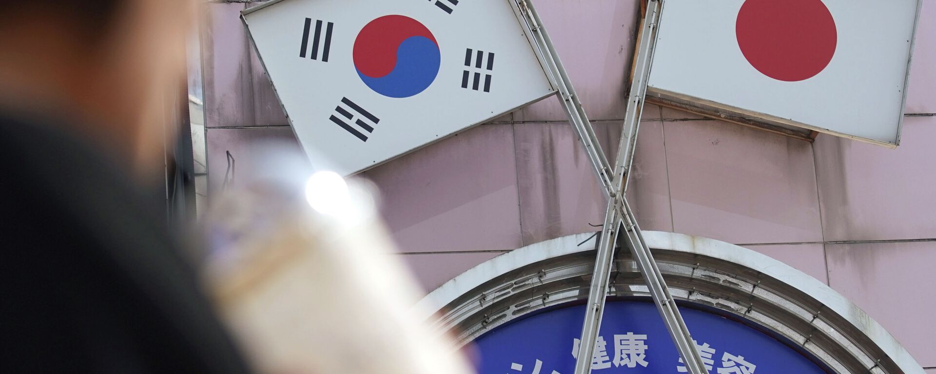 A woman walks past an advertisement featuring Japanese and South Korean flags at a shop in Shin Okubo area in Tokyo Friday, Aug. 2, 2019 - Sputnik International, 1920, 20.03.2023