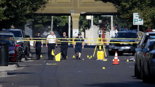 Authorities walk among evidence markers at the scene of a mass shooting, Sunday, Aug. 4, 2019, in Dayton, Ohio. Severral people in Ohio have been killed in the second mass shooting in the U.S. in less than 24 hours, and the suspected shooter is also deceased, police said - Sputnik International