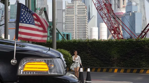 A woman walks towards a U.S. embassy car outside a hotel in Shanghai on Tuesday, July 30, 2019 - Sputnik International