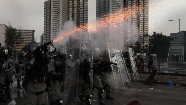 A riot police fires tear gas during a confrontation with protesters on Monday, Aug. 5, 2019. Droves of protesters filled public parks and squares in several Hong Kong districts on Monday in a general strike staged on a weekday to draw more attention to their demands that the semi-autonomous Chinese city's leader resign. - Sputnik International