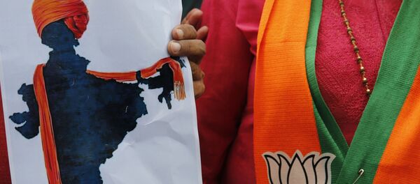 A participant displays an artist's impression of the India map decorated with a saffron shawl as ruling Bharatiya Janata Party (BJP) supporters celebrate government revoking disputed Kashmir's special status in Prayagraj, India, Monday, Aug. 5, 2019. A participant displays an artist's impression of the India map decorated with a saffron shawl as ruling Bharatiya Janata Party (BJP) supporters celebrate government revoking disputed Kashmir's special status in Prayagraj, India, Monday, Aug. 5, 2019. - Sputnik International