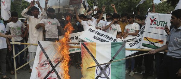 Pakistanis burn a poster of Indian Prime Minster Narendra Modi during a protest to express support and solidarity with Indian Kashmiri people in their peaceful struggle for their right to self-determination, in Lahore, Pakistan, Monday, Aug. 5, 2019. India's government has revoked disputed Kashmir's special status by a presidential order as thousands of troops patrolled and internet and phone services were suspended in the region where most people oppose Indian rule. (AP Photo/K.M. Chaudary) Pakistanis burn a poster of Indian Prime Minster Narendra Modi during a protest to express support and solidarity with Indian Kashmiri people in their peaceful struggle for their right to self-determination, in Lahore, Pakistan, Monday, Aug. 5, 2019. India's government has revoked disputed Kashmir's special status by a presidential order as thousands of troops patrolled and internet and phone services were suspended in the region where most people oppose Indian rule. (AP Photo/K.M. Chaudary) - Sputnik International