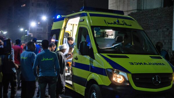 A rescuer helps a man to board an ambulance during the night of August 5, 2019, at the scene of an accident that took place just before midnight on August 4, outside the National Cancer Institute in the Egyptian capital Cairo - Sputnik International
