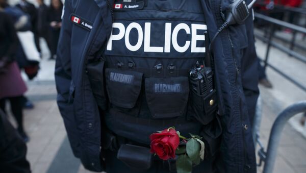 A Toronto Police Officer holds a rose in his belt during a vigil for the victims  (File) - Sputnik International
