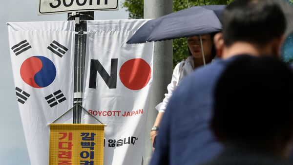Pedestrians walk past a South Korean flag (L) and a banner (R) that reads Boycott Japan hanging along a street in Seoul's Jung-gu district on August 6, 2019.  - Sputnik International