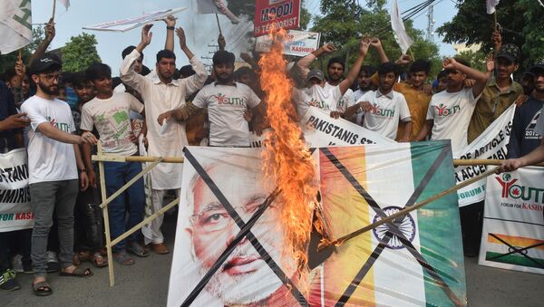 Pakistani activists of the Youth Forum for Kashmir group shout slogans as a a picture of Indian Prime Minister Narendra Modi and Indian flag is burned during a protest in Lahore on August 5, 2019, in reaction to the move by India to abolish Kashmir's special status - Sputnik International