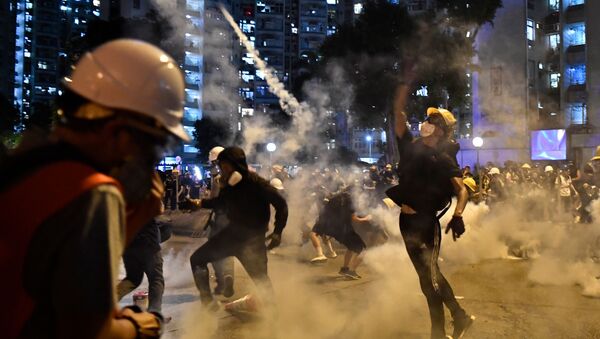 Protesters throw back tear gas fired by the police in Wong Tai Sin during a general strike in Hong Kong on August 5, 2019, as simultaneous rallies were held across seven districts. - Sputnik International