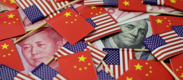 A U.S. dollar banknote featuring American founding father Benjamin Franklin and a China's yuan banknote featuring late Chinese chairman Mao Zedong are seen among U.S. and Chinese flags in this illustration picture taken May 20, 2019 - Sputnik International
