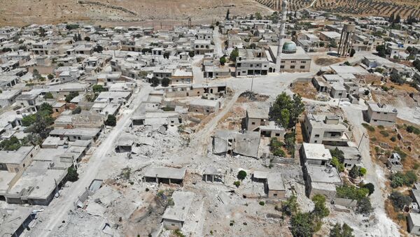 This aerial view taken on August 5, 2019 shows a view of damaged and destroyed buildings in the town of Maaret Hurmah in the southern countryside of Syria's northwestern Idlib province - Sputnik International