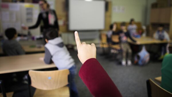 In this 6 October 2015 photo, a child raises her hand to answer a question at a so-called Willkommensklasse (Welcome Class) at an elementary school in Berlin, Germany. - Sputnik International