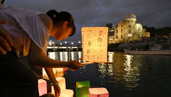 Girl releases paper lanterns on the Motoyasu River facing the gutted Atomic Bomb Dome in Hiroshima - Sputnik International