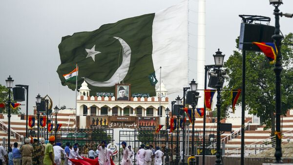 Sikh devotees fold a red carpet as the Pakistani flag is being taken off due to dark clouds looming over at the India-Pakistan Wagah Border, near in Amritsar on August 1, 2019 - Sputnik International