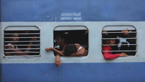 Indian migrant laborers sit inside a train as they prepare to leave the region, at a railway station in Jammu, India, Wednesday, Aug. 7, 2019 - Sputnik International