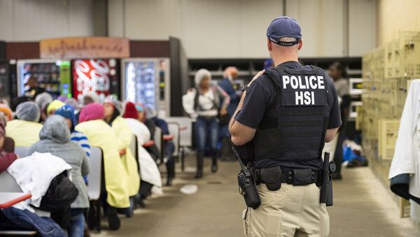Homeland Security Investigations (HSI) officers from Immigration and Customs Enforcement (ICE) look on after executing search warrants and making some arrests at an agricultural processing facility in Canton - Sputnik International