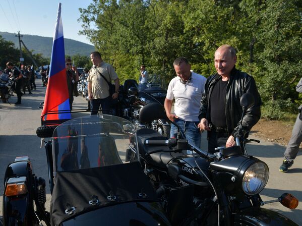 Putin, wearing black leather jacket, standing beside his Ural bike. - Sputnik International