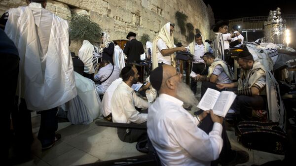 Jewish men pray during the mourning ritual of Tisha B'Av at the Western Wall, the holiest site where Jews can pray in Jerusalem's old city - Sputnik International