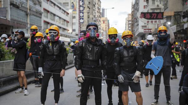 Protesters with protection gears face with riot policemen on a street during the anti-extradition bill protest in Hong Kong, Sunday, Aug. 11, 2019. Police fired tear gas late Sunday afternoon to try to disperse a demonstration in Hong Kong as protesters took over streets in two parts of the Asian financial capital, blocking traffic and setting up another night of likely showdowns with riot police. - Sputnik International