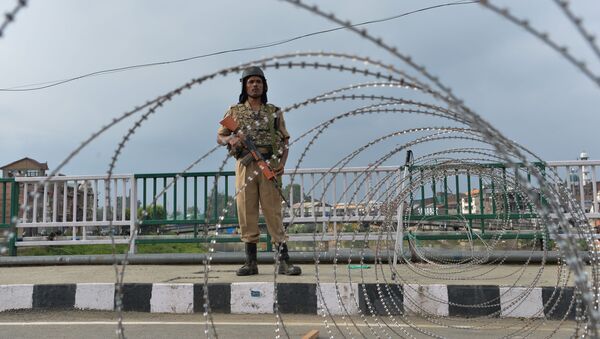 A security personnel stands guard on a street during a lockdown in Srinagar on August 11, 2019, after the Indian government stripped Jammu and Kashmir of its autonomy - Sputnik International