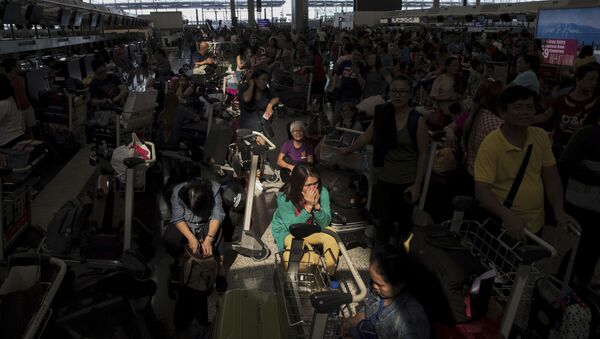 A beam of sunlight is cast on the travellers as they wait at the check-in counters in the departure hall of the Hong Kong International Airport in Hong Kong, Tuesday, Aug. 13, 2019. Protesters clogged the departure area at Hong Kong's reopened airport Tuesday, a day after they forced one of the world's busiest transport hubs to shut down entirely amid their calls for an independent inquiry into alleged police abuse. - Sputnik International
