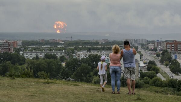 In this photo taken on Monday, Aug. 5, 2019, a family watches explosions at a military ammunition depot near the city of Achinsk in eastern Siberia's Krasnoyarsk region, in Achinsk, Russia.  Russian officials say powerful explosions at a military depot in Siberia left 12 people injured and one missing and forced over 16,500 people to leave their homes.  - Sputnik International