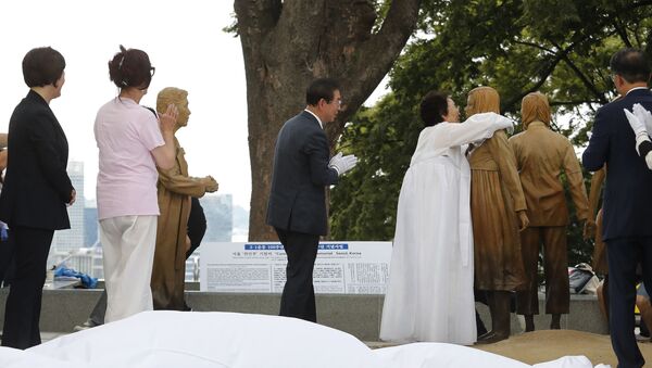 Lee Yong-soo, second from right, who was forced to serve for the Japanese troops as a sex slave during World War II, hugs a statue of a girl symbolising the issue of wartime comfort women during it unveiling ceremony in Seoul, South Korea, Wednesday, Aug. 14, 2019. - Sputnik International