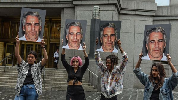 In this file photo taken on July 8, 2019, a protest group called Hot Mess hold up photos of Jeffrey Epstein in front of the Federal courthouse on July 8, 2019 in New York City. - Sputnik International