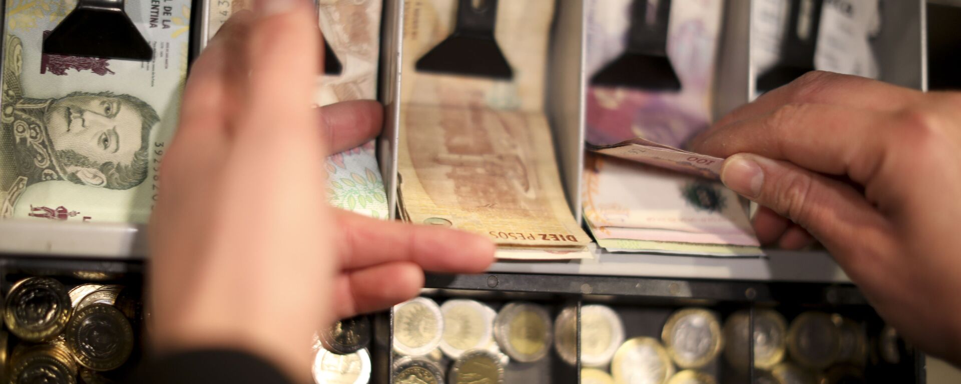A man holds a 100 peso bill in the cashier of a restaurant in Buenos Aires, Argentina, Wednesday, Aug. 14, 2019. President Mauricio Macri announced economic relief for poor and working-class Argentines that include an increased minimum wage, reduced payroll taxes, a bonus for informal workers and a freeze in gasoline prices. The conservative leader said Wednesday he's acting in recognition of the anger Argentines expressed in Sunday's primary election, when Macri trailed his populist rival by 15 percentage points. - Sputnik International, 1920, 20.11.2023