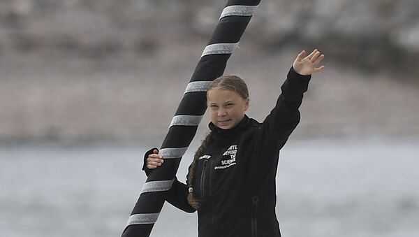 Swedish climate activist Greta Thunberg waves from aboard the Malizia II IMOCA class sailing yacht off the coast of Plymouth, southwest England, on 14 August 2019, as she starts her journey across the Atlantic to New York, where she will attend the UN Climate Action Summit next month. - Sputnik International