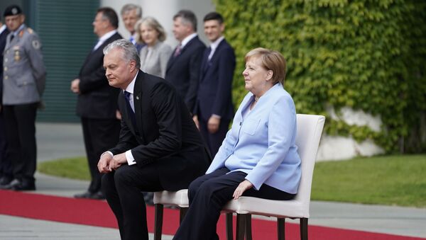 German Chancellor Angela Merkel and Lithuania's President Gitanas Nauseda sit down to listen to their national anthems during an official welcoming ceremony on August 14, 2019 at the Chancellery in Berlin - Sputnik International