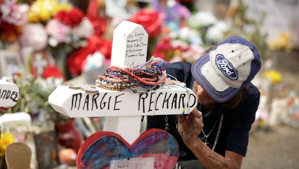 Antonio Basco, whose wife Margie Reckard was murdered during a shooting at a Walmart store, touches a white wooden cross bearing the name of his late wife, at a memorial for the victims of the shooting in El Paso, Texas, U.S. - Sputnik International