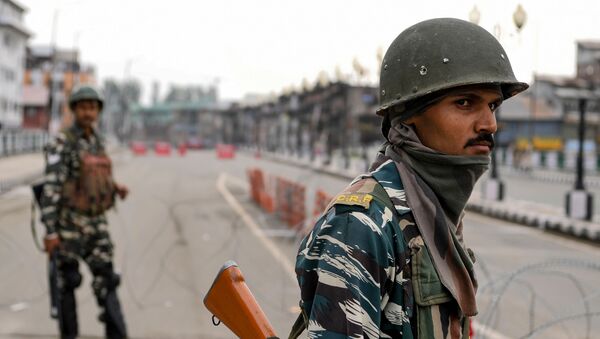 Security personnel stand guard on a deserted road during a lockdown in Srinagar on August 15, 2019, as India celebrates its 73rd Independence Day.  - Sputnik International