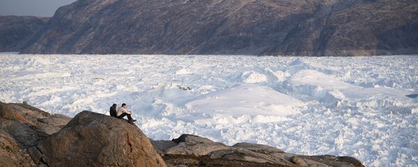 In this Aug. 16, 2019, photo, New York University student researchers sit on a rock overlooking the Helheim glacier in Greenland. In this Aug. 16, 2019, photo, New York University student researchers sit on a rock overlooking the Helheim glacier in Greenland. - Sputnik International