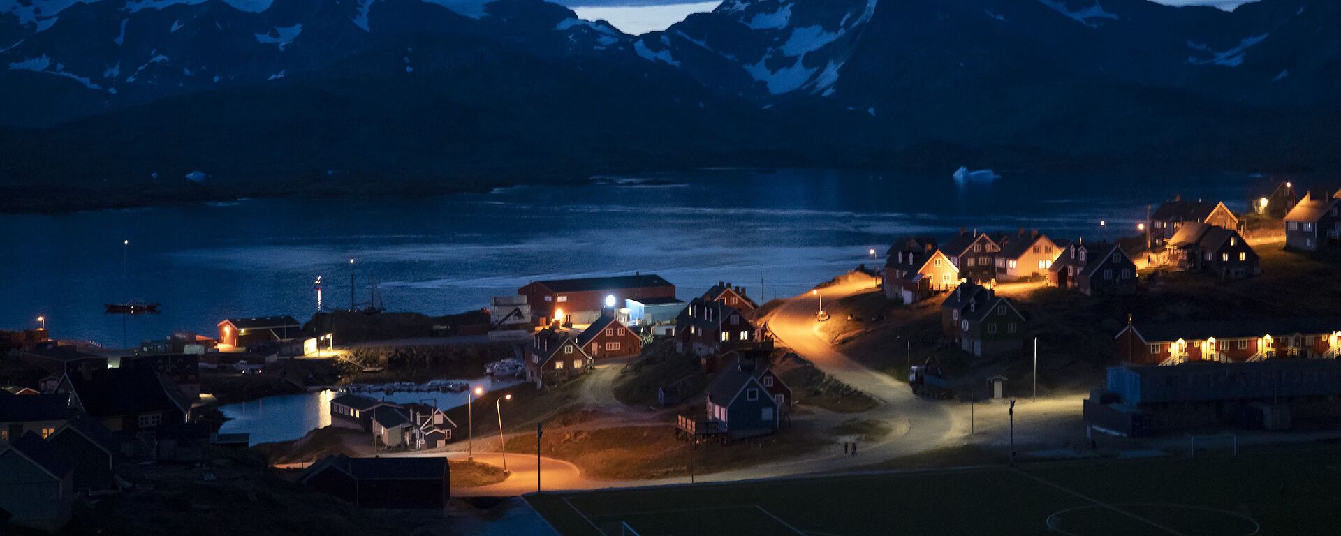 In this photo taken late Friday, Aug. 16, 2019, homes are illuminated after the sunset in Tasiilaq, Greenland.  - Sputnik International, 1920, 23.11.2021