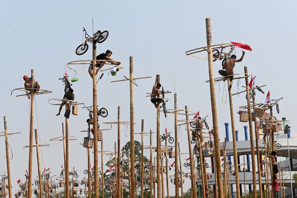 Participants climb greasy poles at a beach in Jakarta on August 17, 2019, during Panjat Pinang, a pole climbing contest to celebrate Indonesia's 74th anniversary of independence from Dutch rule.  - Sputnik International
