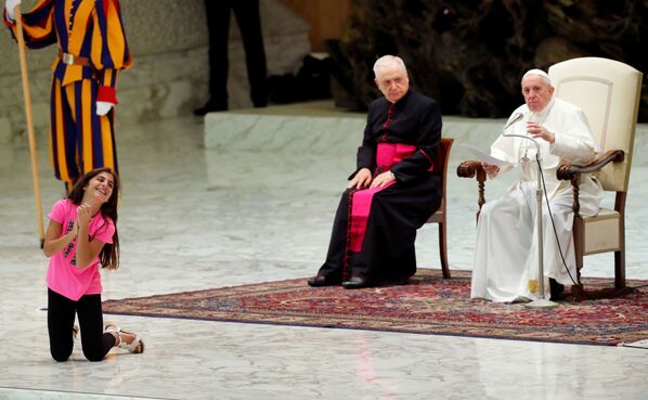 A girl reacts next to Pope Francis as he leads the weekly general audience in Paul VI Hall at the Vatican, August 21, 2019.   - Sputnik International