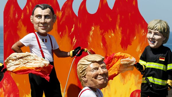 Oxfam activists wearing giant papier mache heads depicting G7 leaders U.S. President Donald Trump , French President Emmanuel Macron and German Chancellor Angela Merkel pose dressed as firemen to draw attention to fighting inequality, on the eve of the G7 summit in Biarritz, France, August 23, 2019.  - Sputnik International
