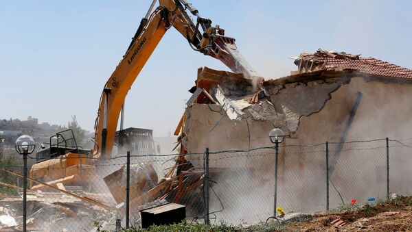An Israeli machinery demolishes a Palestinian building housing an apartment and a restaurant as the building owners said they were informed by the Israeli forces that they did not obtain a construction permit, in Beit Jala in the Israeli-occupied West Bank August 26, 2019.  - Sputnik International