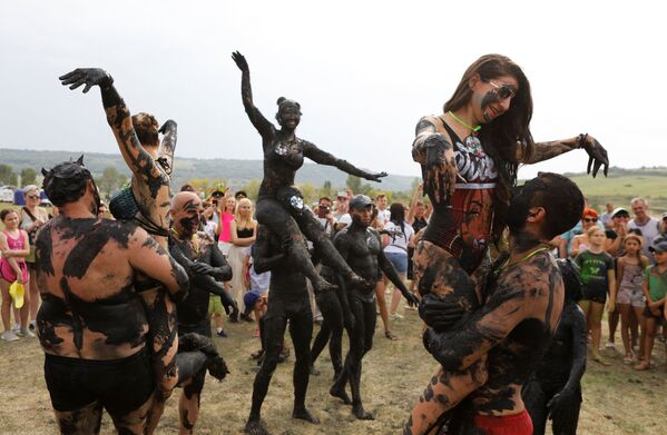 People covered with mineral-rich mud take part in the Iron mud festival in the town of Zheleznovodsk, in Stavropol region, Russia August 24, 2019. People covered with mineral-rich mud take part in the Iron mud festival in the town of Zheleznovodsk, in Stavropol region, Russia August 24, 2019. - Sputnik International