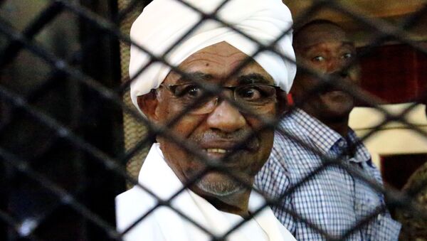 Sudan's former president Omar Hassan al-Bashir smiles as he is seen inside a cage at the courthouse where he is facing corruption charges, in Khartoum, Sudan August 31, 2019 - Sputnik International