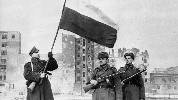 Soviet troops pose as Polish soldier raises Polish flag over Warsaw in January 1945. The liberation of Poland cost the Red Army 600,000 casualties. - Sputnik International