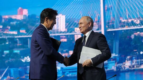 Russian President Vladimir Putin shakes hands with Japanese Prime Minister Shinzo Abe after a plenary session of the Eastern Economic Forum in Vladivostok, Russia September 5, 2019 - Sputnik International