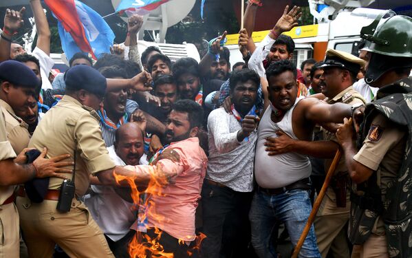 Members of the Karnataka Congress scuffle with police as they burn tyres and shout slogans against Indian Prime Minister Narendra Modi and Home Minister Amit Shah during a protest staged by the party in Bangalore on September 4, 2019 - Sputnik International